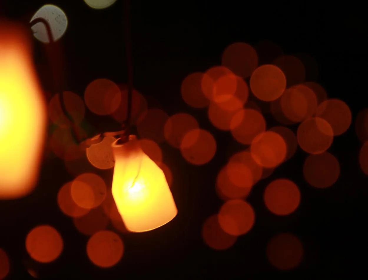A hanging lamp glowing against soft bokeh lights