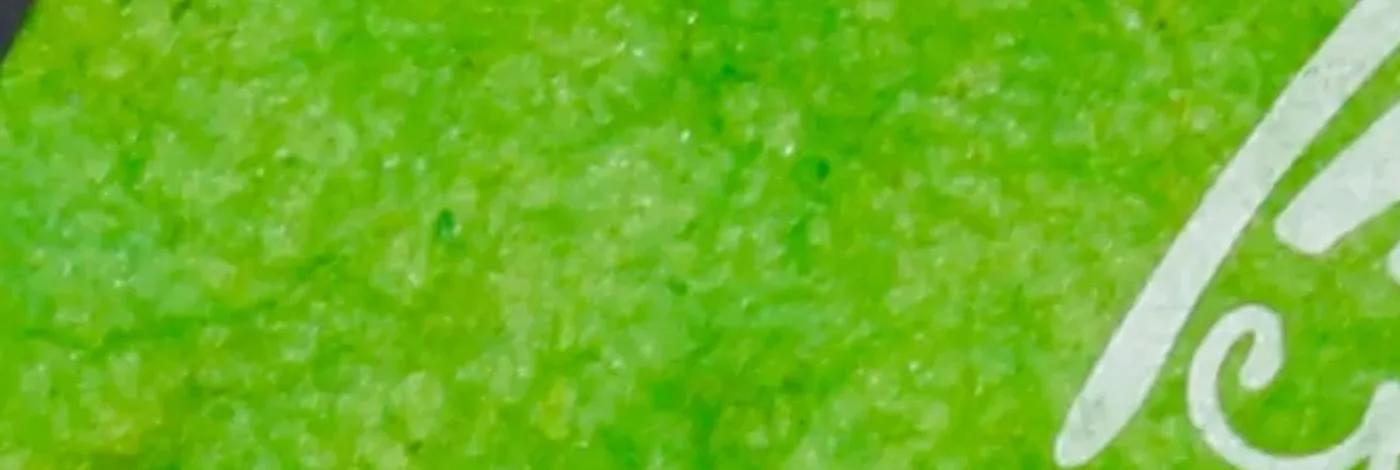 Green lokta paper, close up, with the curl of the logo printed in white